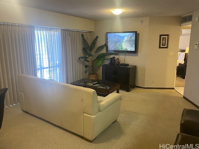 living room featuring light carpet and a textured ceiling