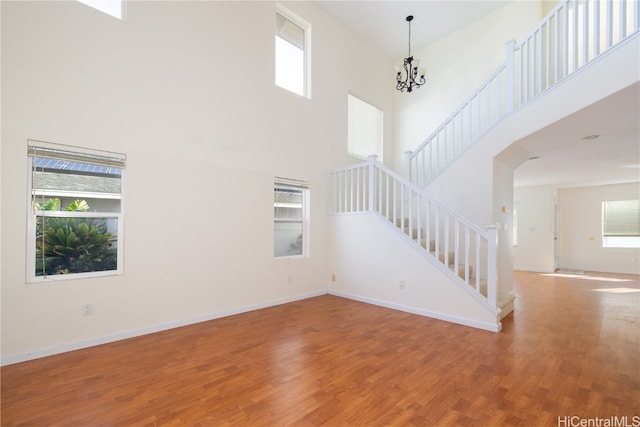 unfurnished living room with a towering ceiling and a healthy amount of sunlight