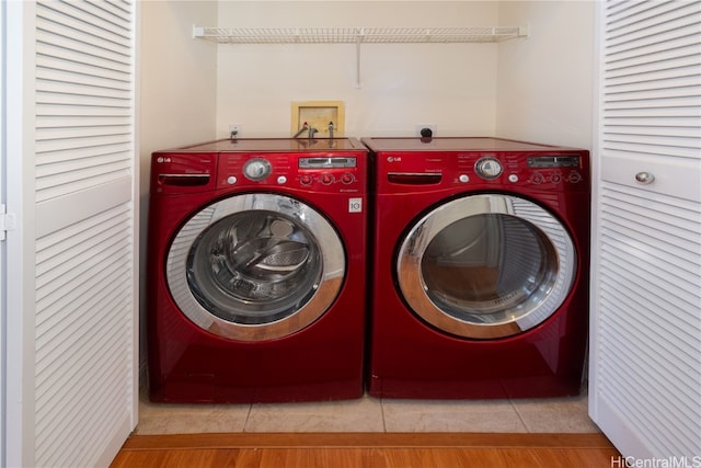 laundry area featuring light tile patterned floors and washing machine and clothes dryer