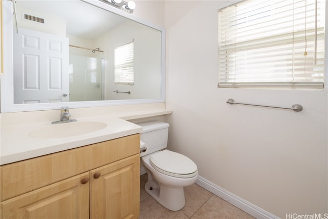 bathroom featuring toilet, tile patterned flooring, vanity, and walk in shower