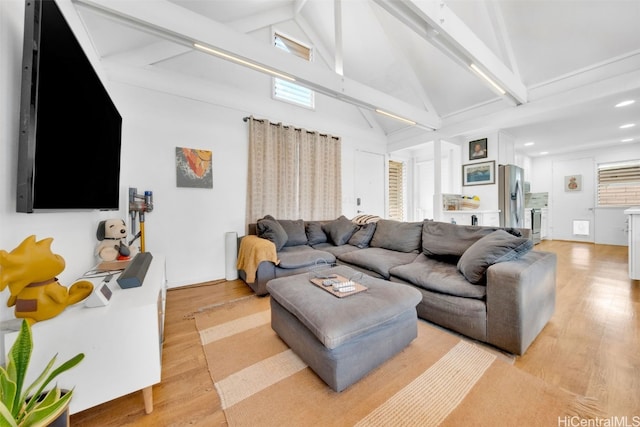 living room featuring beamed ceiling, high vaulted ceiling, and light hardwood / wood-style flooring