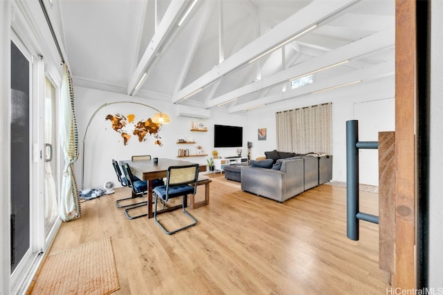 living room with a wall unit AC, vaulted ceiling with beams, and light hardwood / wood-style flooring