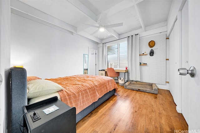 bedroom featuring beamed ceiling, hardwood / wood-style flooring, and ceiling fan