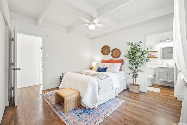 bedroom featuring ceiling fan, beamed ceiling, connected bathroom, wood finished floors, and coffered ceiling
