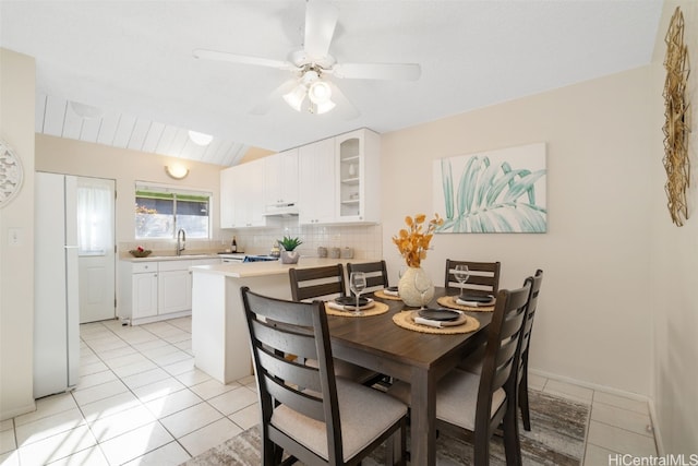 dining room featuring ceiling fan, light tile patterned floors, and sink