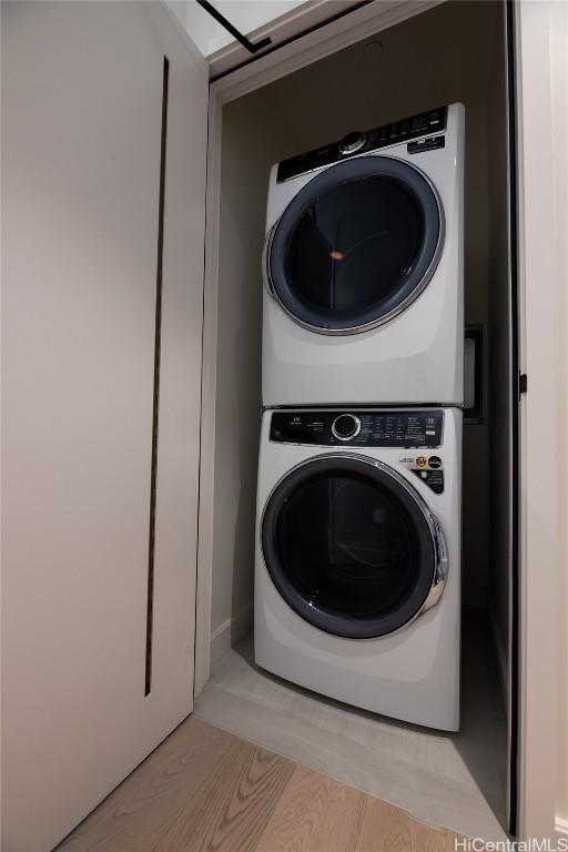 washroom featuring light hardwood / wood-style floors and stacked washer and dryer