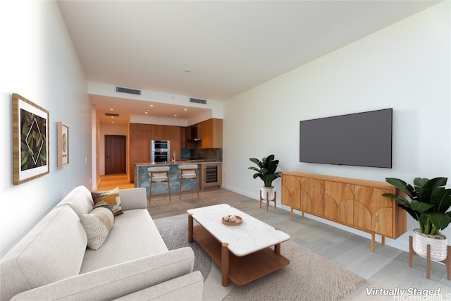 living room featuring wine cooler and light hardwood / wood-style floors