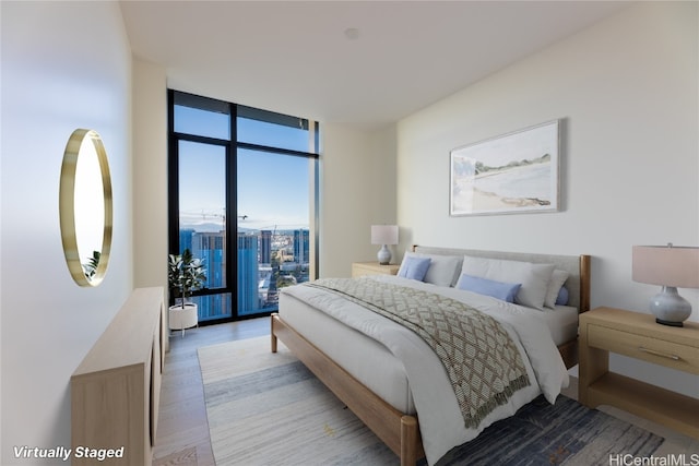 bedroom featuring light hardwood / wood-style flooring and expansive windows