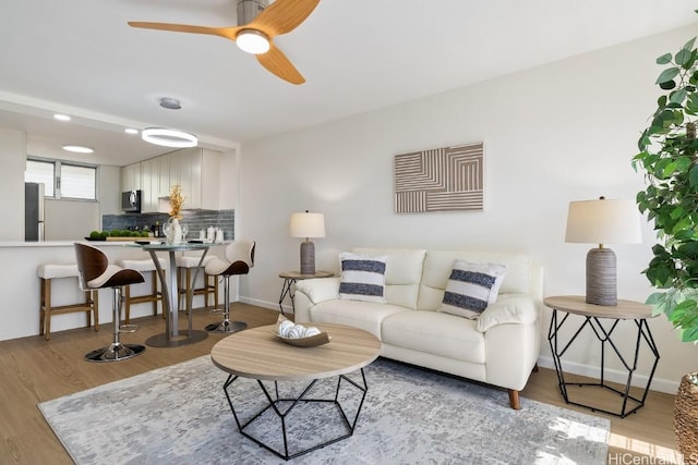 living room featuring light hardwood / wood-style floors and ceiling fan