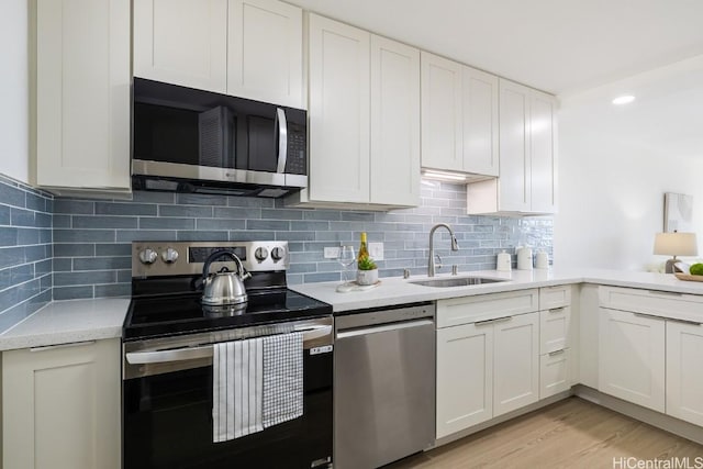 kitchen with sink, white cabinets, and appliances with stainless steel finishes