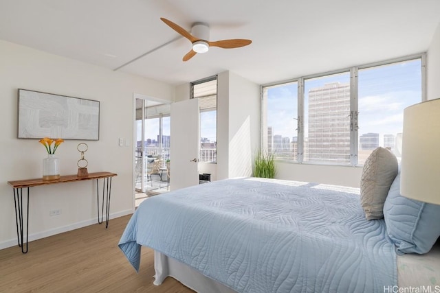 bedroom featuring multiple windows, ceiling fan, and light hardwood / wood-style flooring