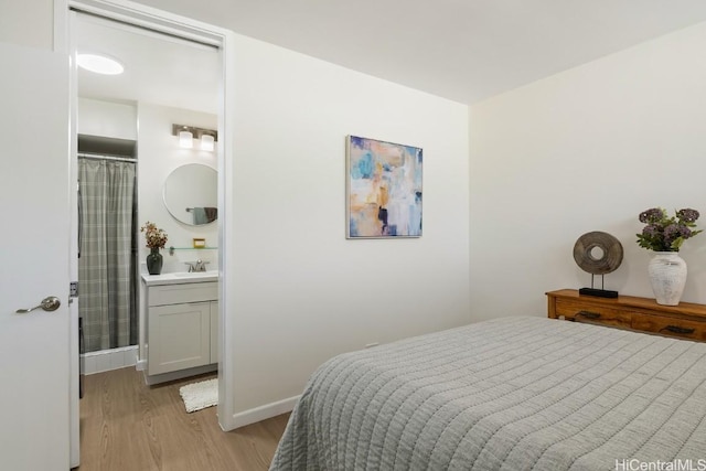 bedroom featuring light hardwood / wood-style flooring and sink