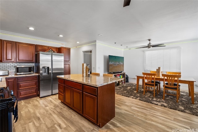 kitchen with a center island, tasteful backsplash, light hardwood / wood-style flooring, appliances with stainless steel finishes, and ornamental molding