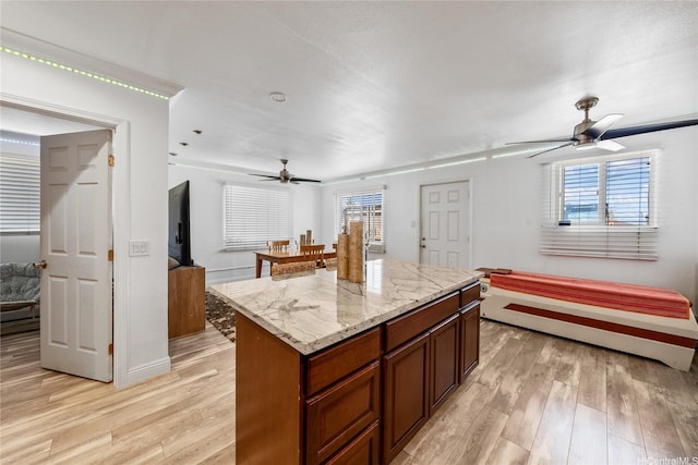 613 Kalakaua St, Wailuku, HI 96793 - kitchen with a ceiling fan, light wood-style flooring, open floor plan, a kitchen island, and light stone countertops