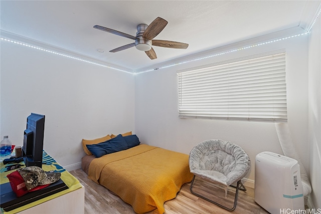 bedroom with ceiling fan, ornamental molding, and light wood-type flooring