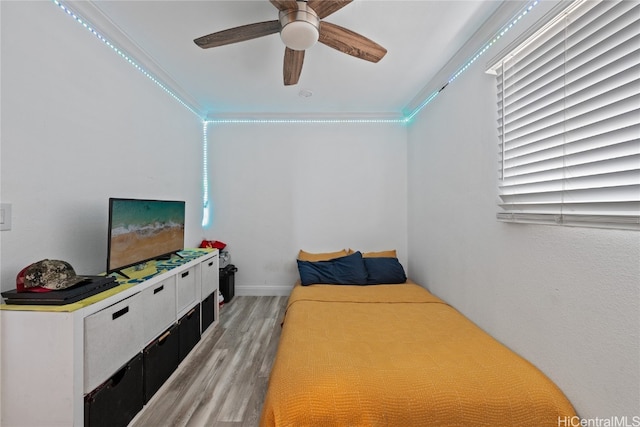 bedroom with ceiling fan, light hardwood / wood-style floors, and crown molding