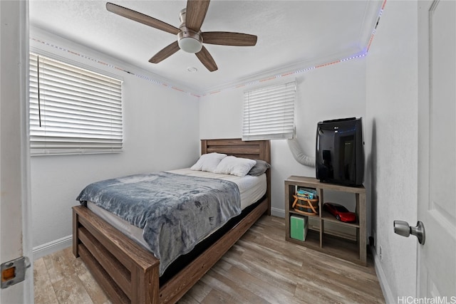 bedroom featuring hardwood / wood-style flooring, ceiling fan, and ornamental molding