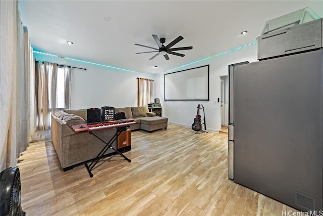 living room featuring ceiling fan and light hardwood / wood-style floors