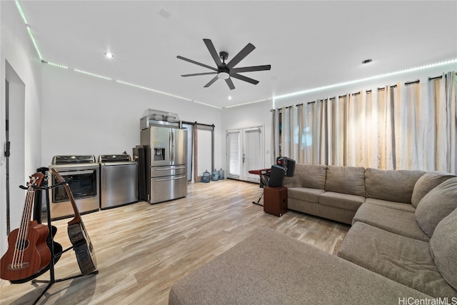 living room with washer and dryer, ceiling fan, and light wood-type flooring