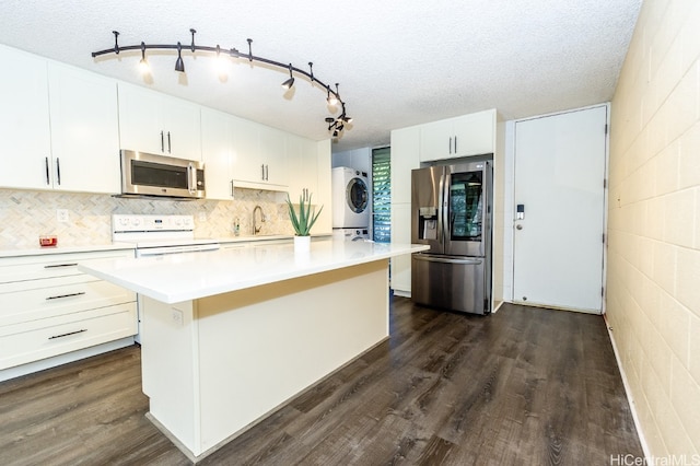 kitchen with a textured ceiling, a center island, white cabinetry, and stainless steel appliances