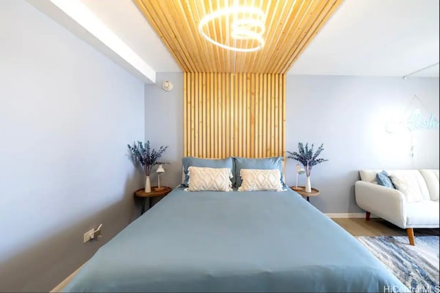 bedroom featuring wooden ceiling, wood-type flooring, and an inviting chandelier