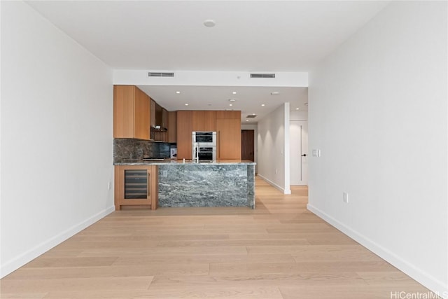 kitchen featuring modern cabinets, wine cooler, visible vents, and backsplash