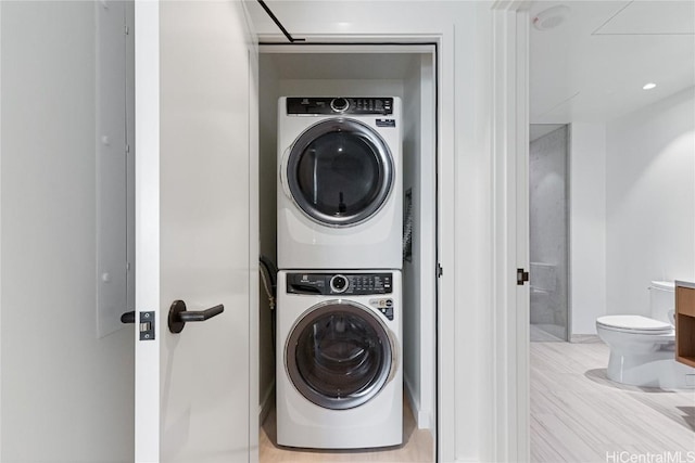 clothes washing area with laundry area and stacked washing maching and dryer