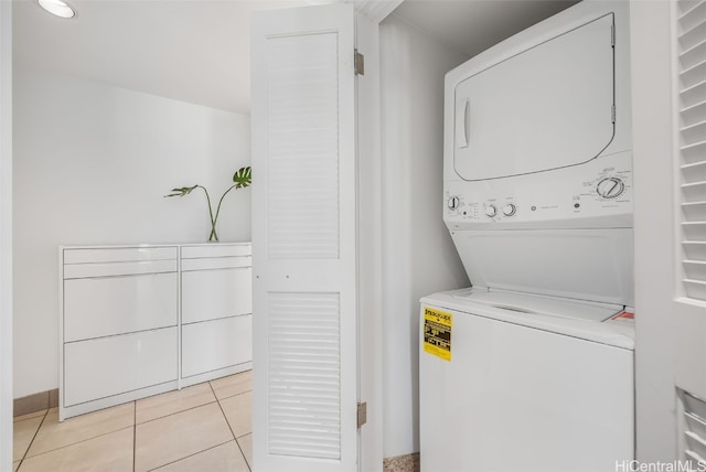 washroom featuring light tile patterned floors and stacked washer and dryer