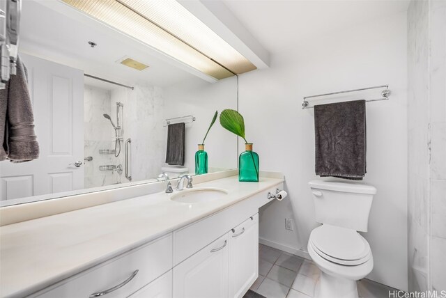 bathroom featuring a shower, vanity, tile patterned floors, and toilet