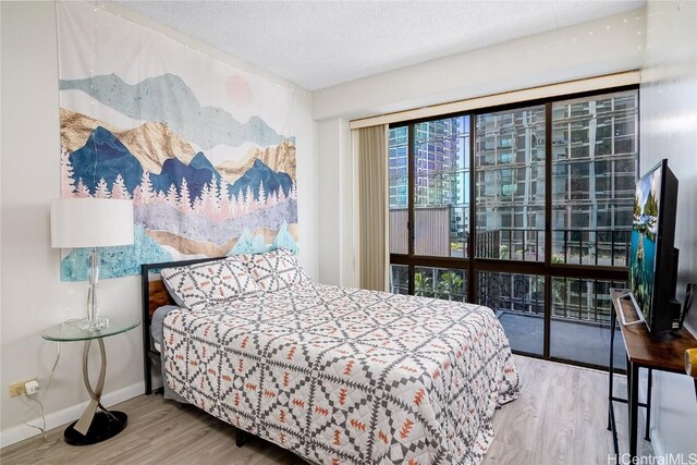 bedroom with a textured ceiling and hardwood / wood-style flooring