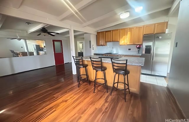 kitchen featuring sink, stainless steel refrigerator with ice dispenser, ceiling fan, vaulted ceiling with beams, and dark hardwood / wood-style flooring