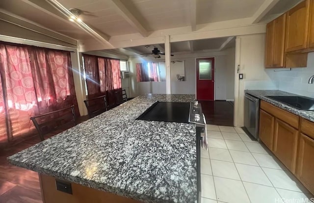 kitchen with beamed ceiling, dishwasher, sink, a center island, and ceiling fan