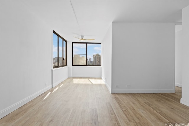 unfurnished room with light wood-type flooring and ceiling fan