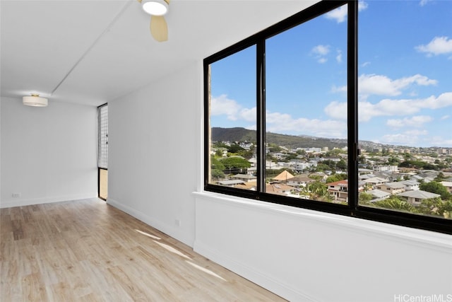 empty room with ceiling fan and light wood-type flooring