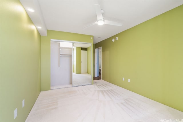 unfurnished bedroom with light carpet, a closet, and ceiling fan