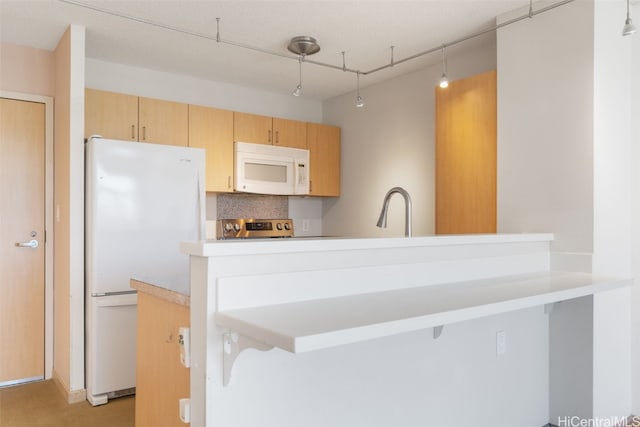 kitchen featuring kitchen peninsula, sink, pendant lighting, and white appliances