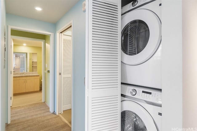 washroom featuring light hardwood / wood-style floors and stacked washer and dryer