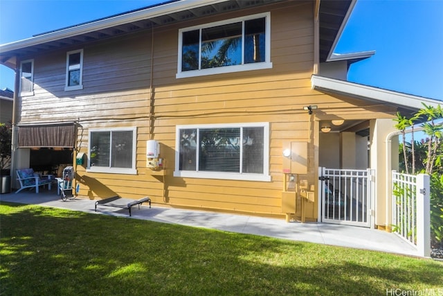 rear view of property featuring a patio area and a lawn