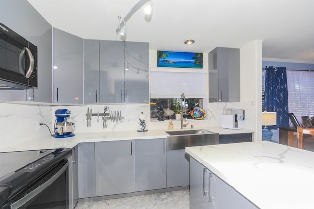 kitchen with gray cabinetry, backsplash, black appliances, ornamental molding, and light stone counters