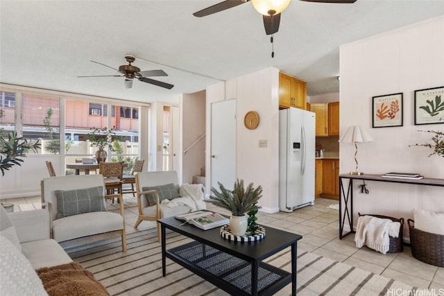 living room featuring ceiling fan, light tile patterned floors, and a textured ceiling