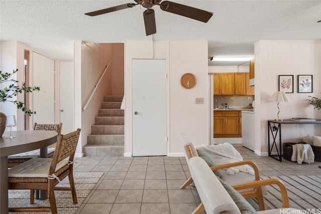 tiled living room with ceiling fan, sink, and a textured ceiling