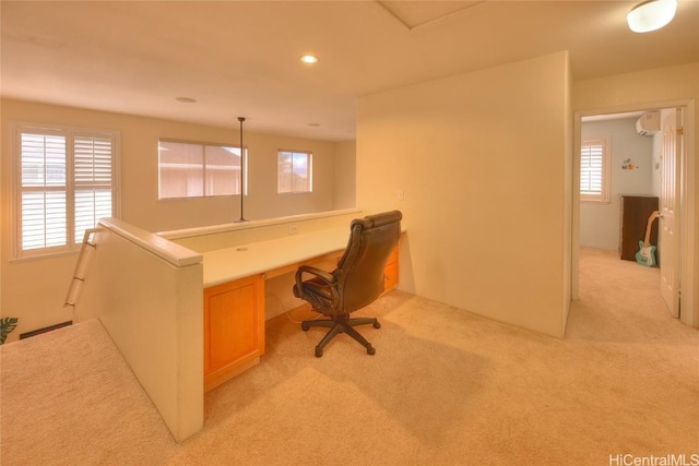 carpeted home office featuring a wall mounted air conditioner and a healthy amount of sunlight