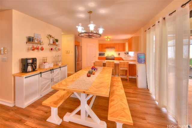 dining area featuring an inviting chandelier and light hardwood / wood-style flooring