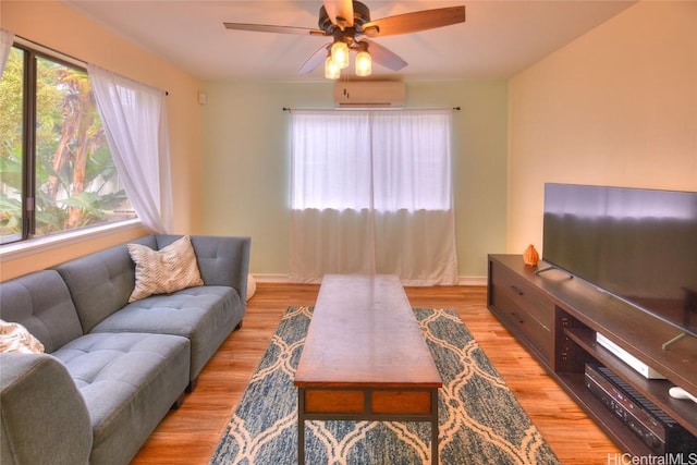 living room with a wall mounted air conditioner, light hardwood / wood-style floors, and ceiling fan