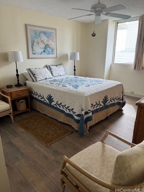 bedroom with a textured ceiling, dark hardwood / wood-style flooring, and ceiling fan