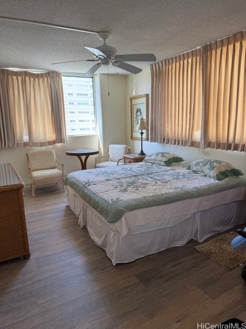 bedroom featuring hardwood / wood-style floors, a textured ceiling, and ceiling fan