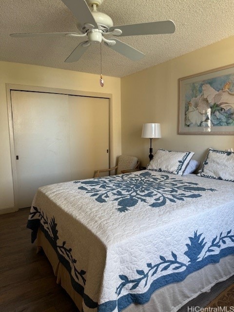 bedroom featuring a textured ceiling, a closet, dark hardwood / wood-style floors, and ceiling fan