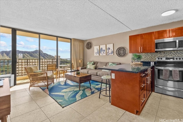 tiled living room with a mountain view, a wall of windows, and a textured ceiling