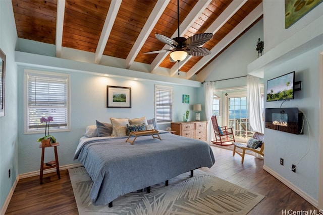 bedroom with beamed ceiling, multiple windows, dark wood-type flooring, and ceiling fan