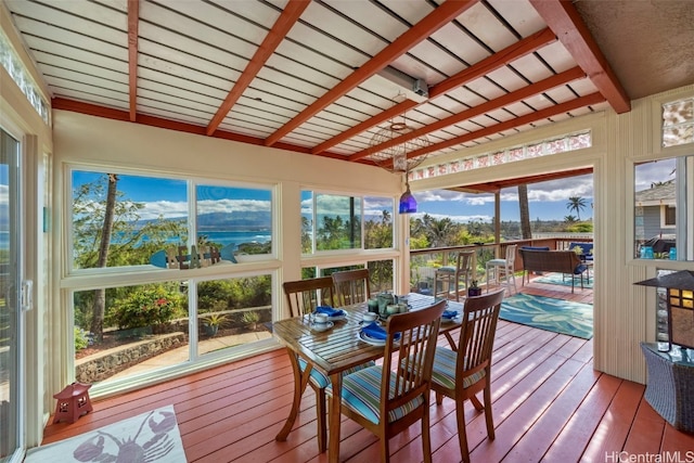 sunroom / solarium featuring a water view and beamed ceiling